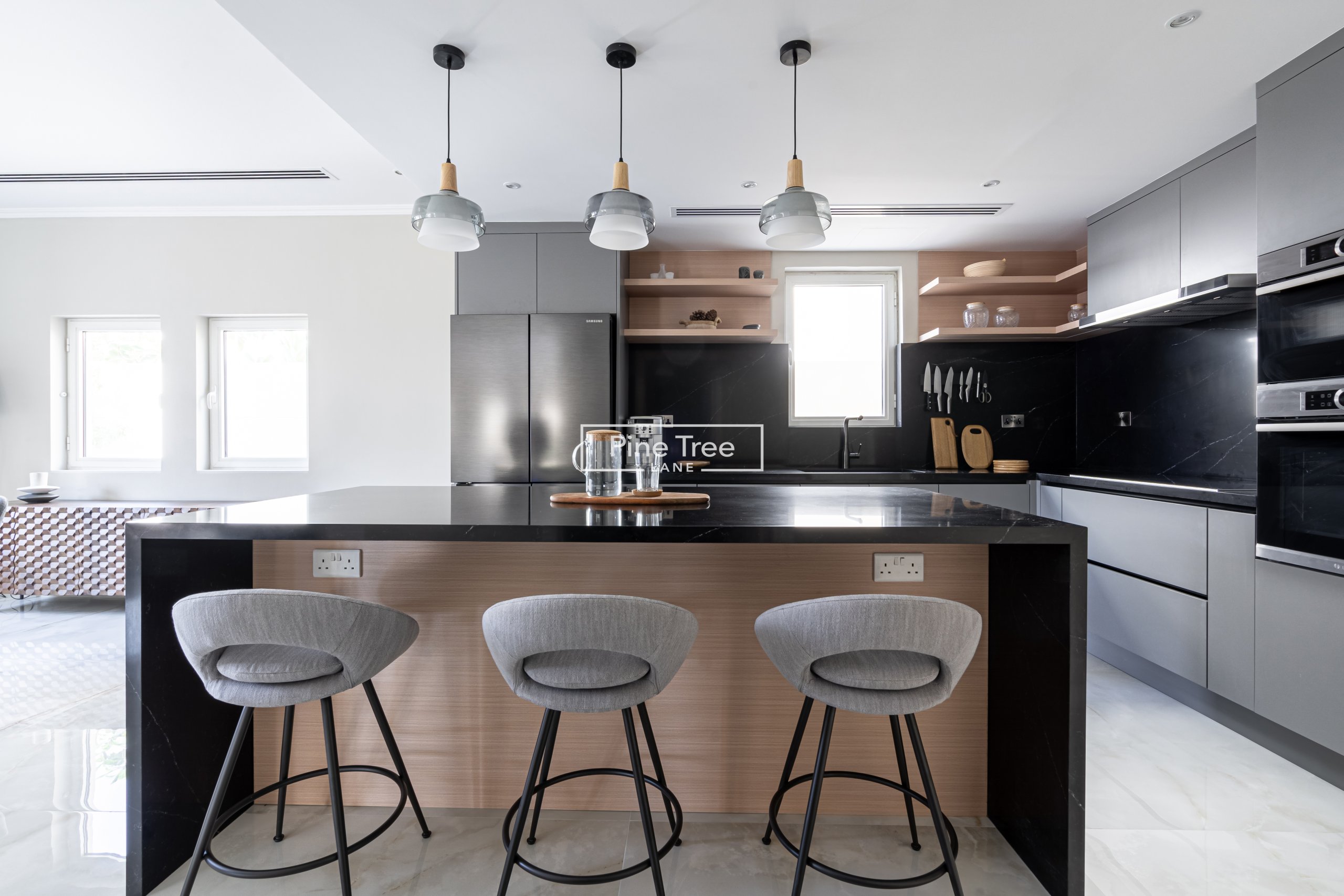 kitchen with black marble island and bar stools