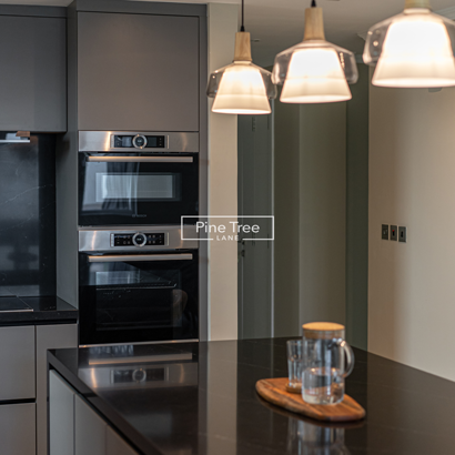 Kitchen with pendant lights and black marble countertop