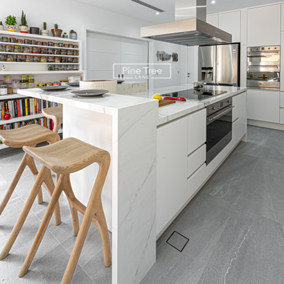 modern kitchen features two sleek wooden bar stools
