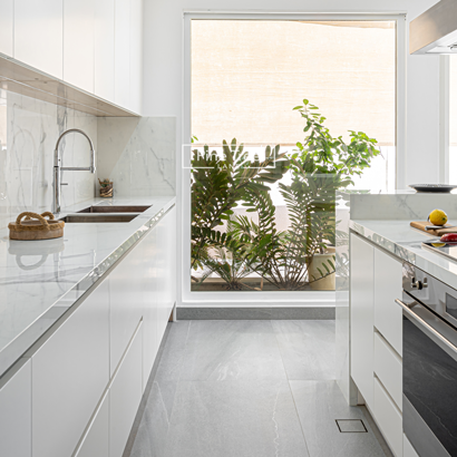 modern kitchen with clean white surfaces, built-in ovens