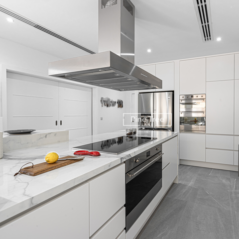 kitchen with sleek white cabinetry and marble countertops