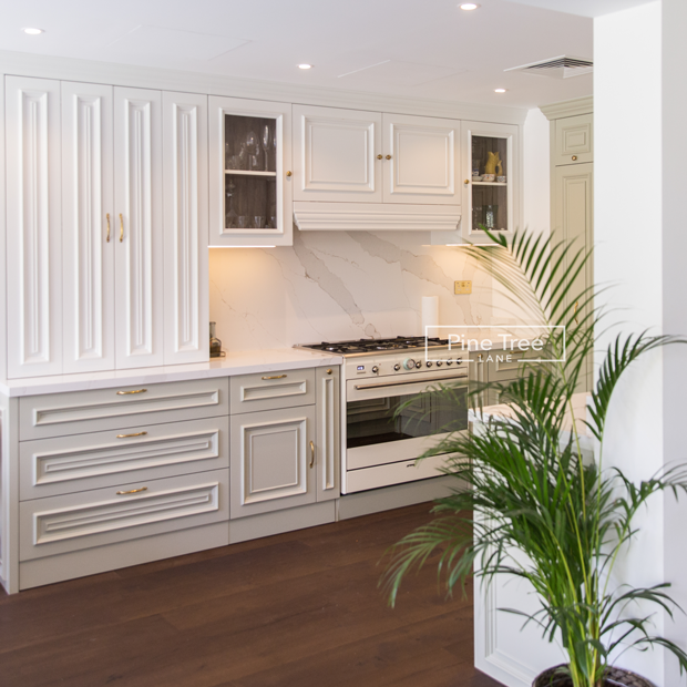 Sage green and white kitchen with brass accents
