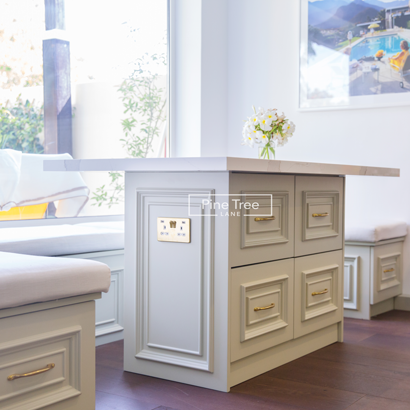 breakfast nook featuring a white island with drawers