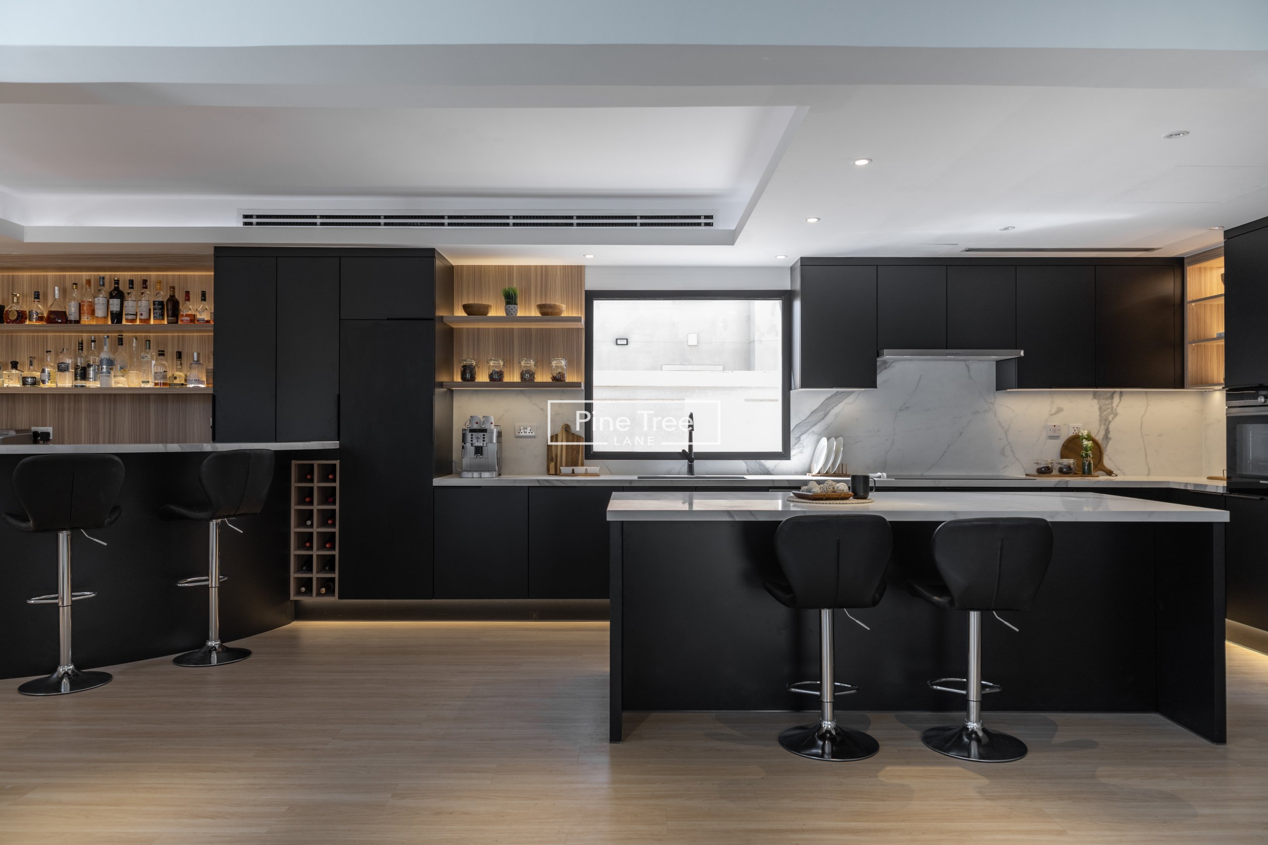 Modern kitchen with black cabinets and cozy bar space