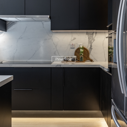 Matte black kitchen cabinets softly lit with marble backsplash
