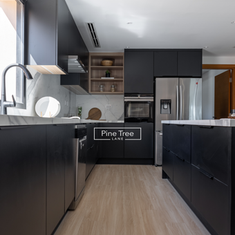 Refined kitchen with black cabinets and wood accent