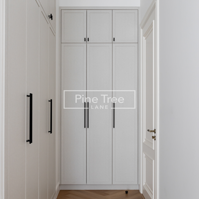 Full-height white cabinetry with black handles