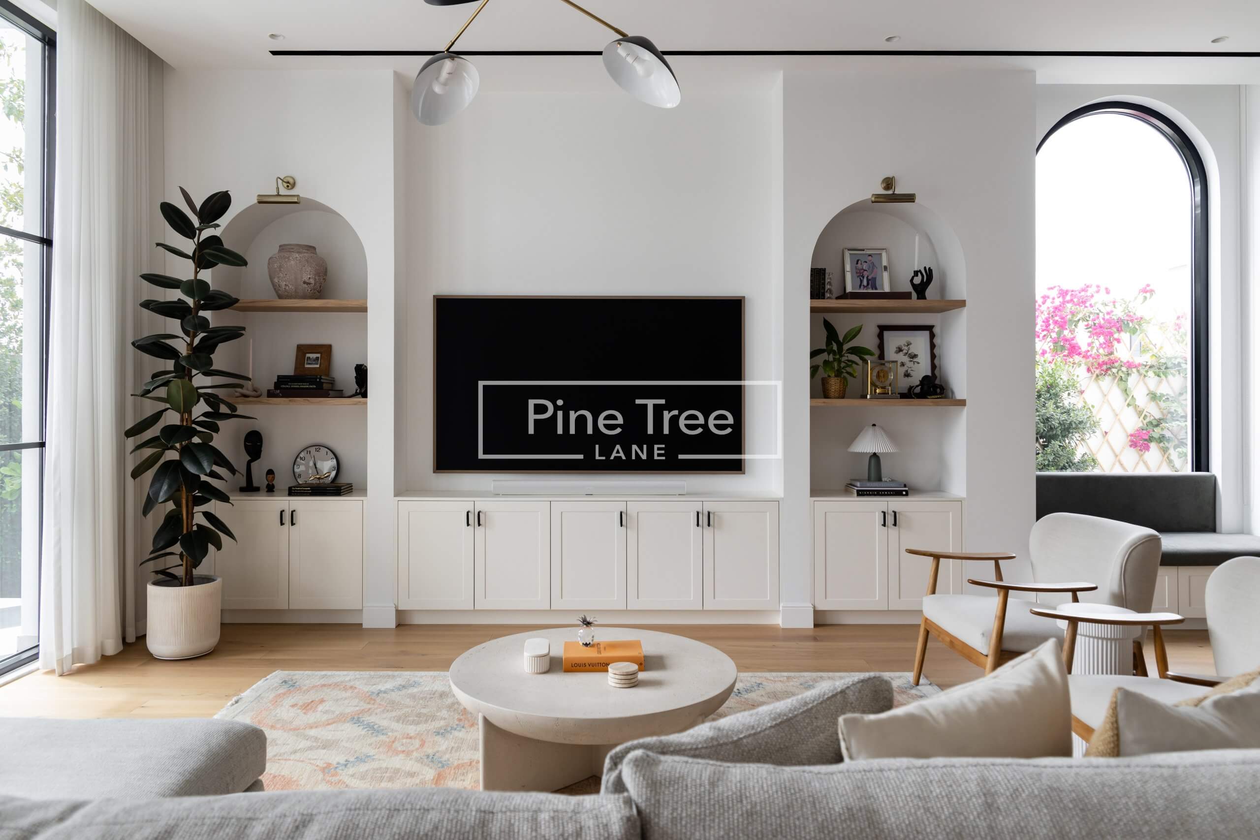 living space with white cabinets, open shelves, and wood floor