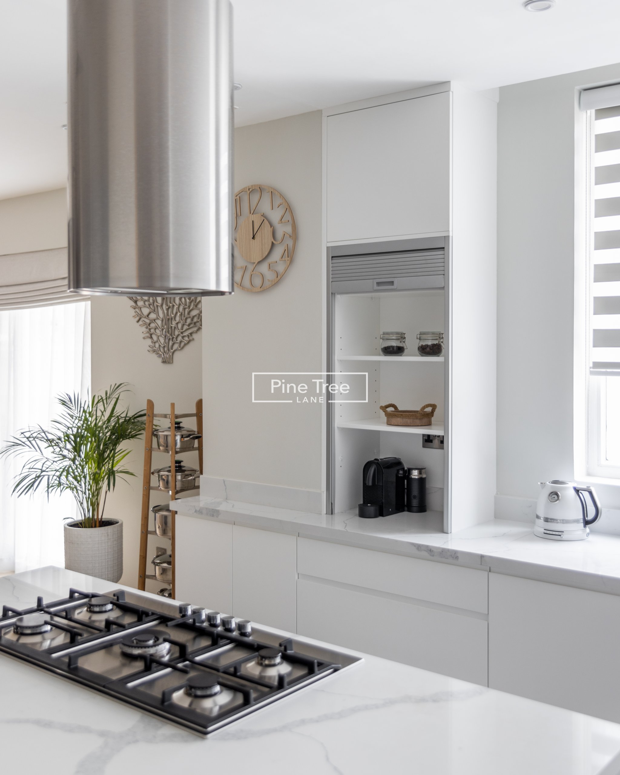Kitchen with built-in cooking area and white joinery.
