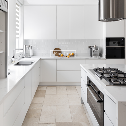 Kitchen features white cabinetry and marble countertops