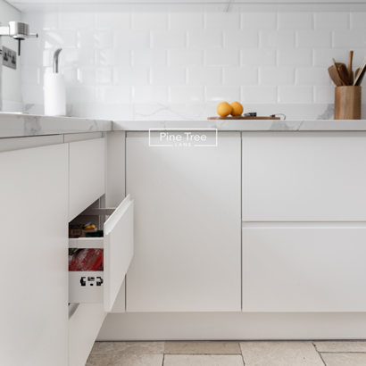 Kitchen with white cabinetry and beige stone flooring