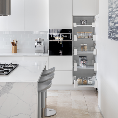 Modern kitchen with white cabinets, marble counters, and bar stools