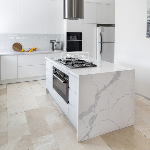 Kitchen with white cabinets and marble countertops