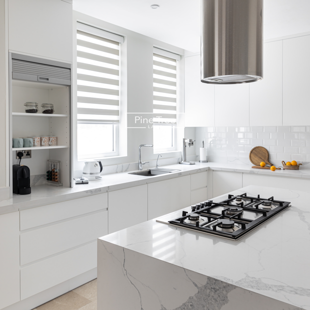 kitchen with sleek joinery and stone flooring