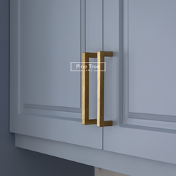 Gold-tone handle on modern kitchen cabinet