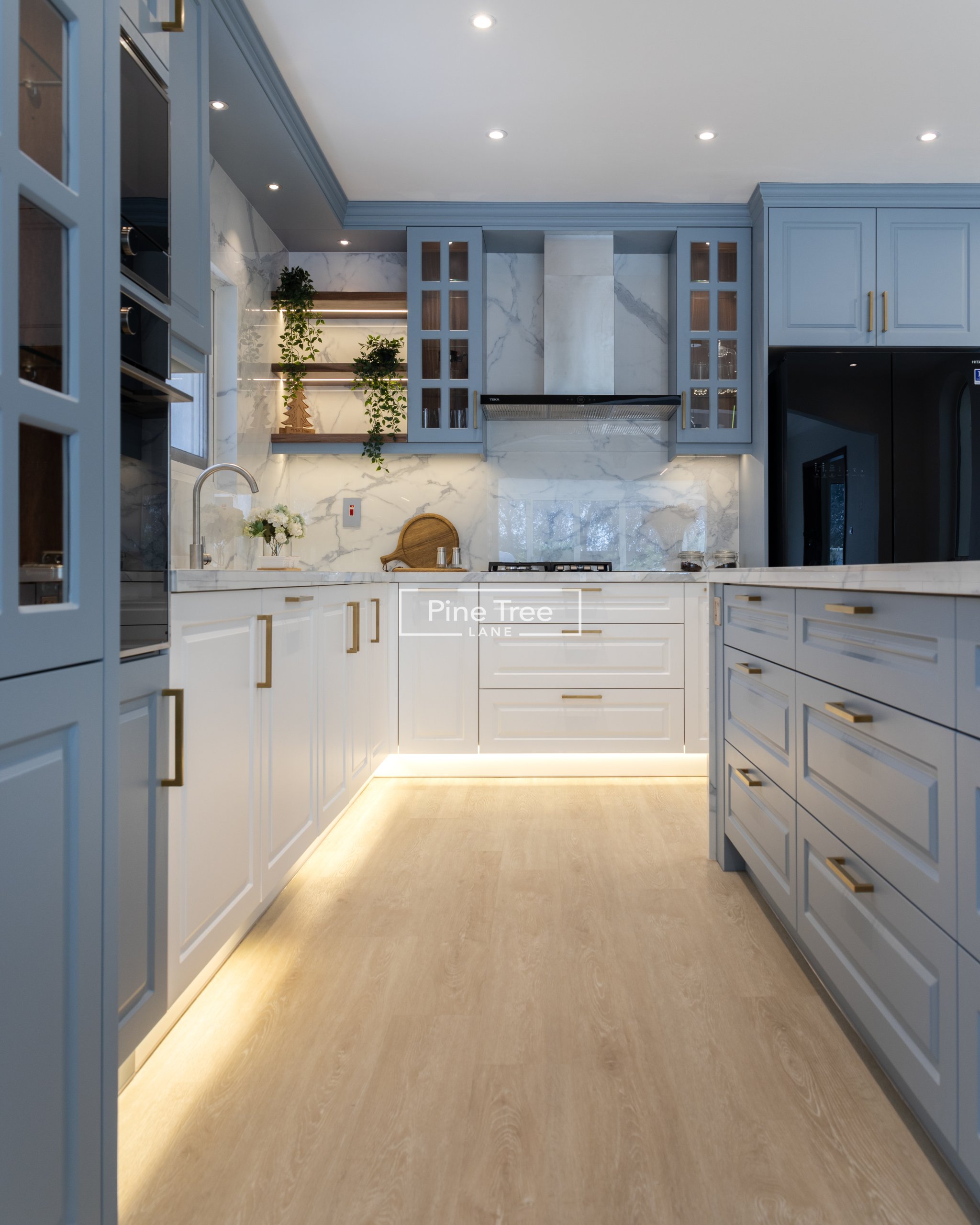White and blue kitchen cabinets with golden surface lighting