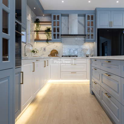 Detailed view of blue cabinetry with bold brass handles in a luxury kitchen