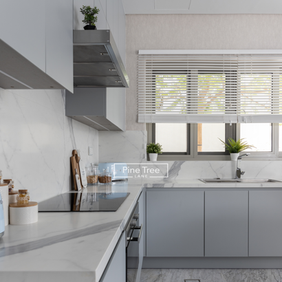 Kitchen with grey cabinetry and marble countertops