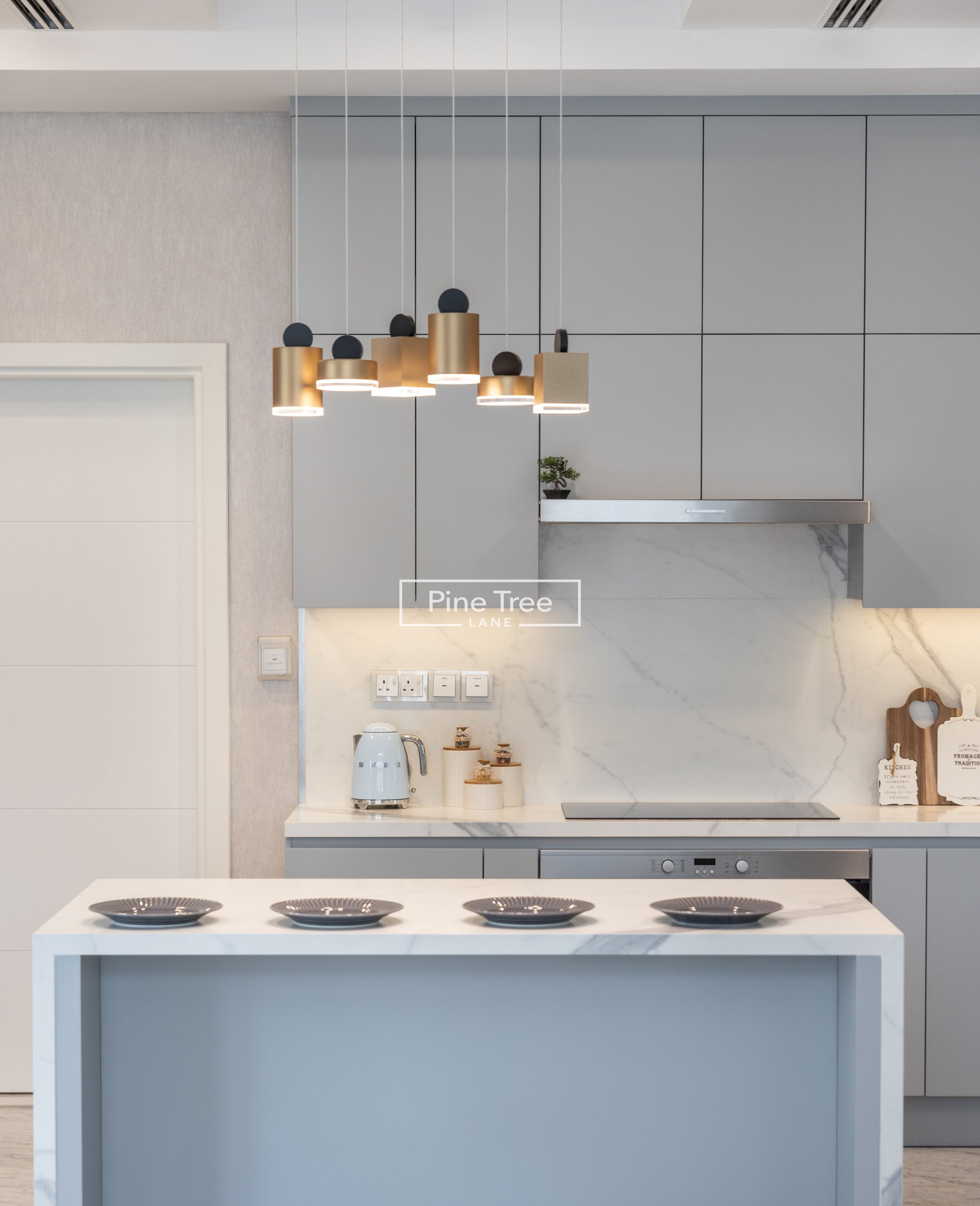 Kitchen grey cabinets with gold pendant lights