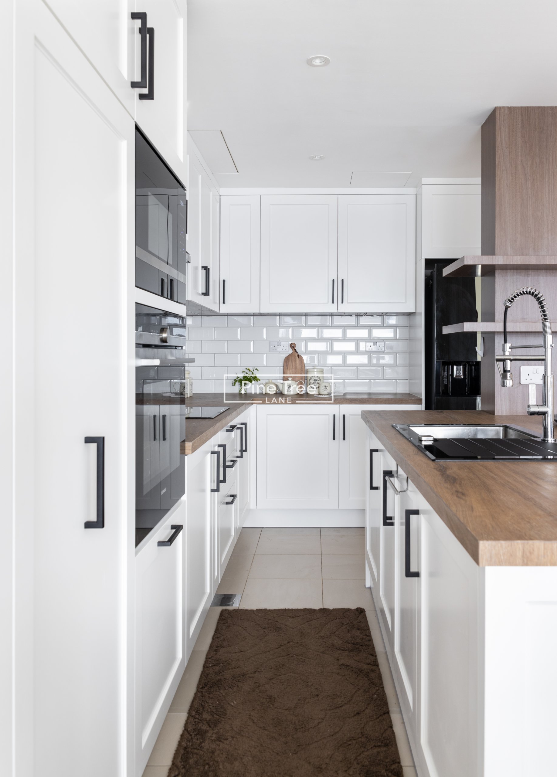 kitchen featuring shaker cabinets and black handles