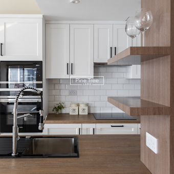 kitchen featuring crisp white cabinetry, warm wood countertops