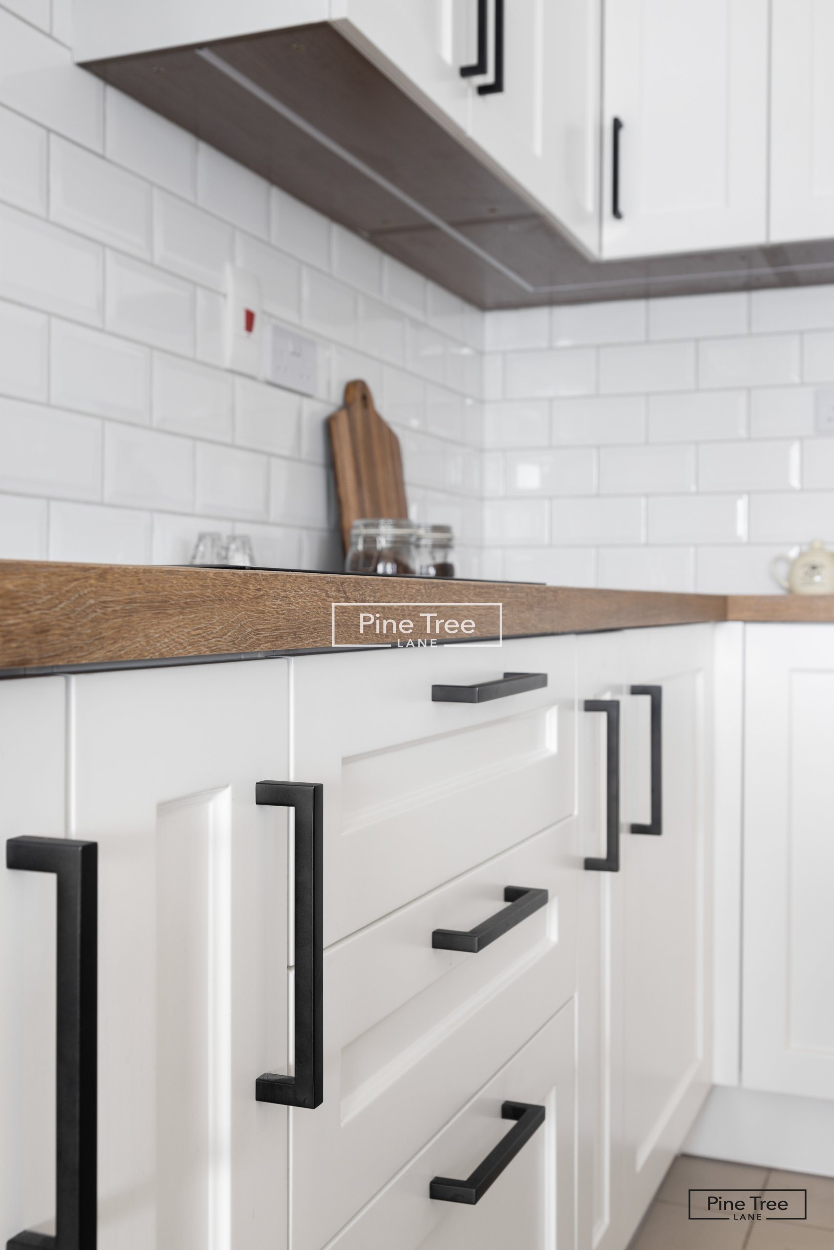 kitchen featuring white cabinets and black handles