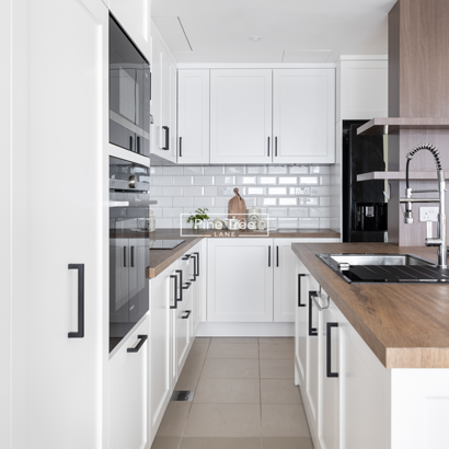kitchen featuring shaker cabinets and black handles
