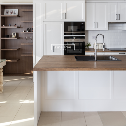 White kitchen cabinets with wooden countertop