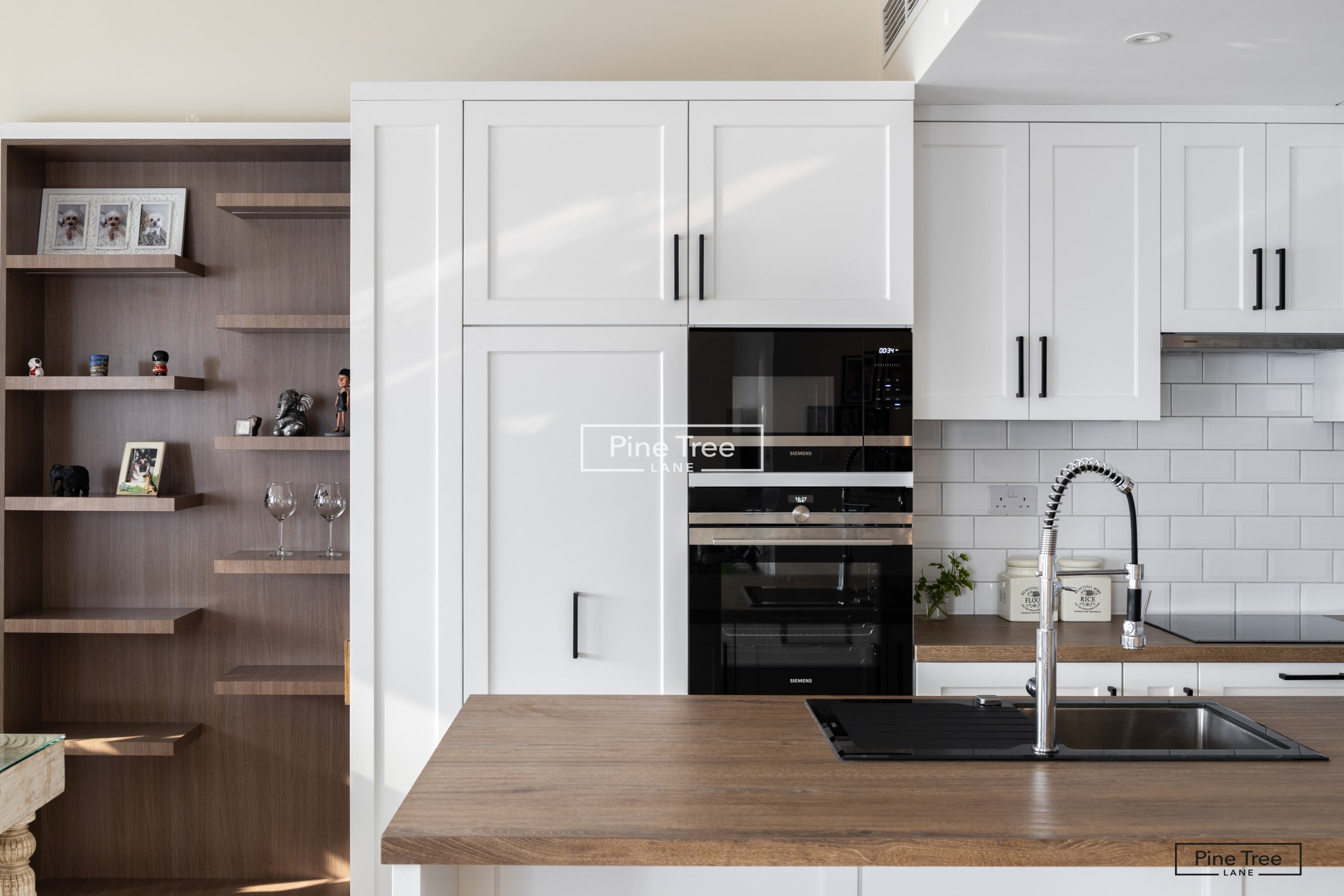 kitchen featuring white cabinets and wood shelves