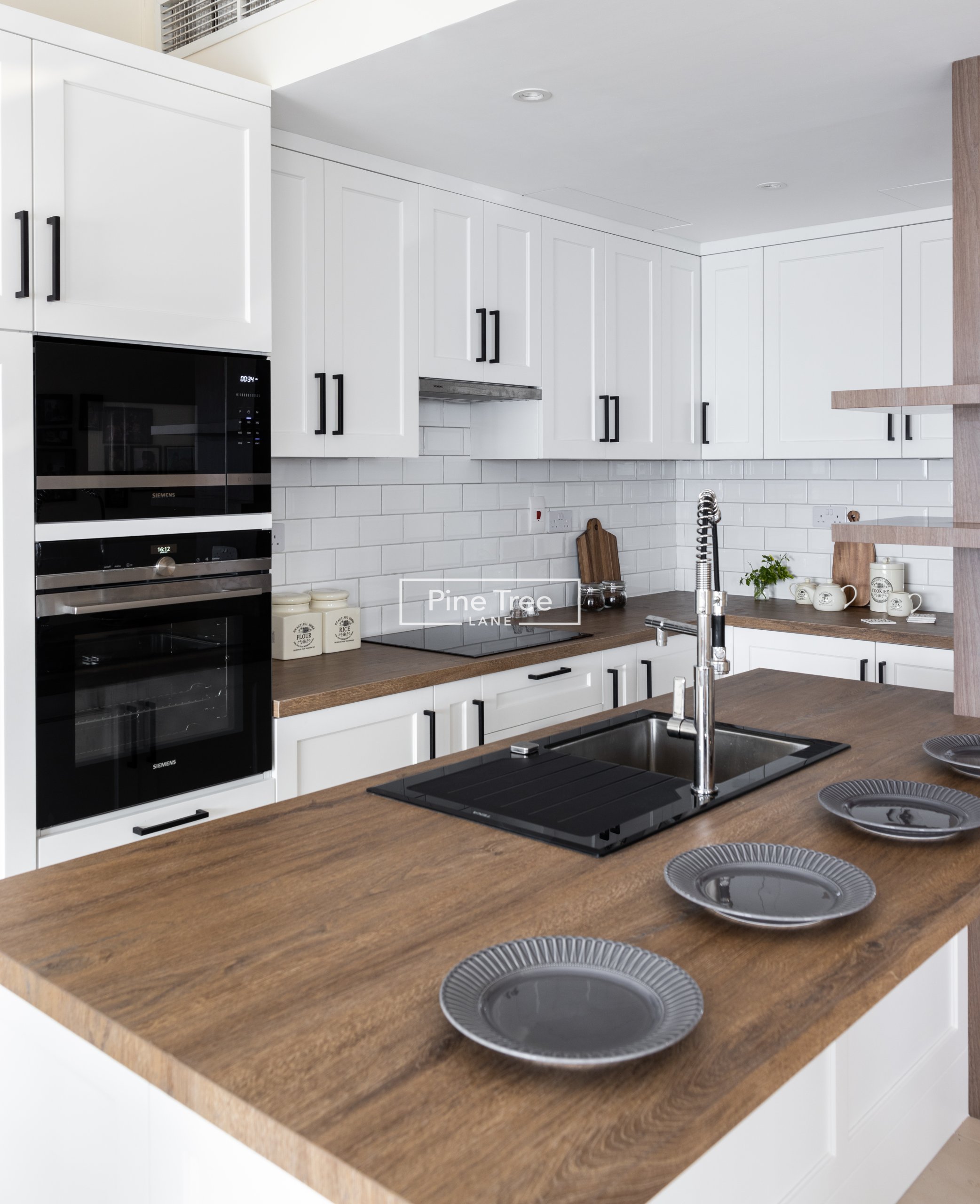 kitchen with white shaker cabinets and warm wood