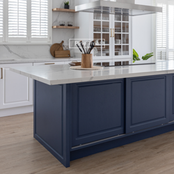 Deep navy-blue kitchen cabinets with white marble countertop