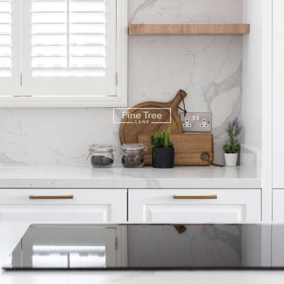 Modern kitchen nook with marble backsplash and oak shelves