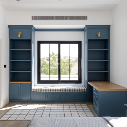 Bedroom nook with built-in seating and blue cabinetry