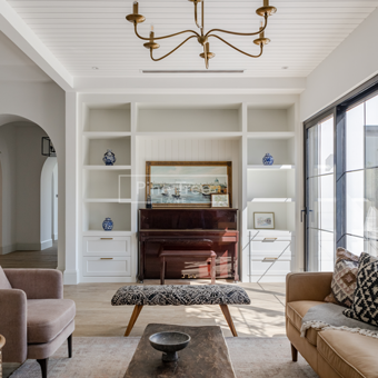 living room featuring white cabinetry and brass accents