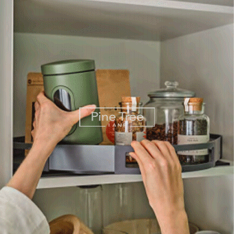 Woman organizing kitchen accessories in storage cabinet
