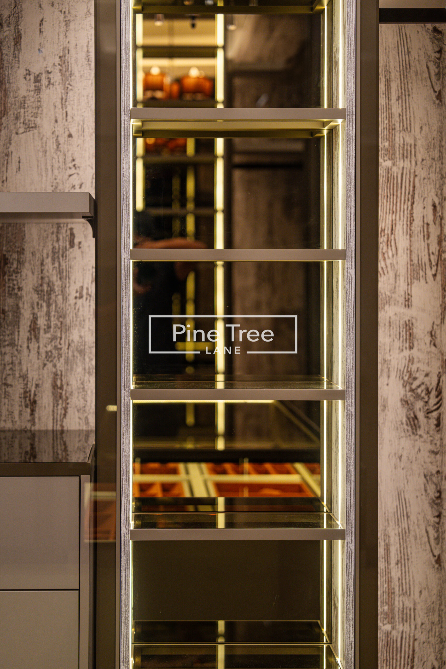Glass display shelves with integrated warm LED lighting and wood-textured backing