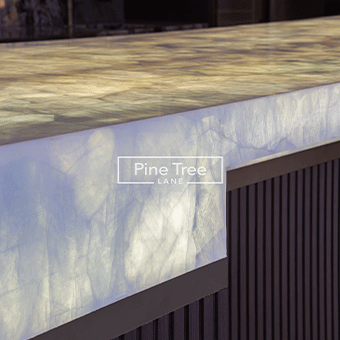 Bespoke entertainment bar with onyx countertop and fluted wood base