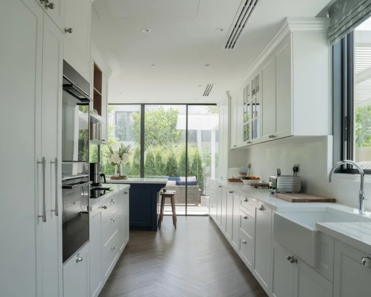 Modern kitchen with white cabinetry, wooden island, and marble countertops