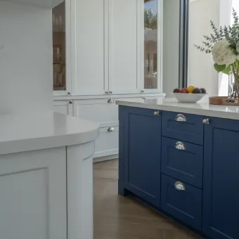 Blue kitchen island with white marble countertop and modern sink setup