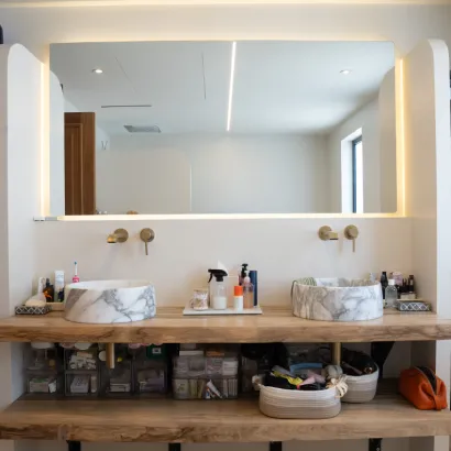 Modern bathroom vanity with backlit mirror and dual vessel sinks