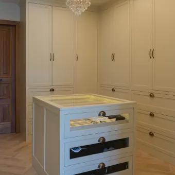 White closet island with drawers and glass top display