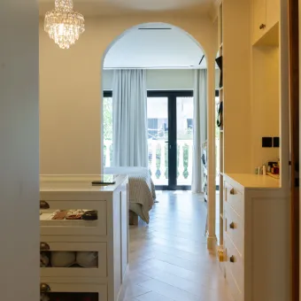 Archway hallway view leading to bright master bedroom